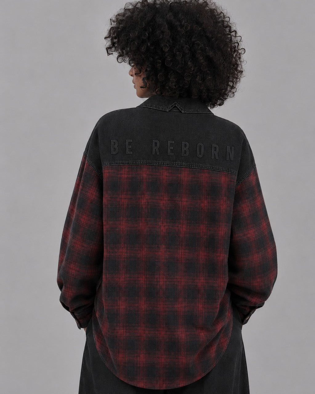 Detalle estampado a tono BE REBORN en espalda de camisa oversize AÜL con tejido de algodón premium