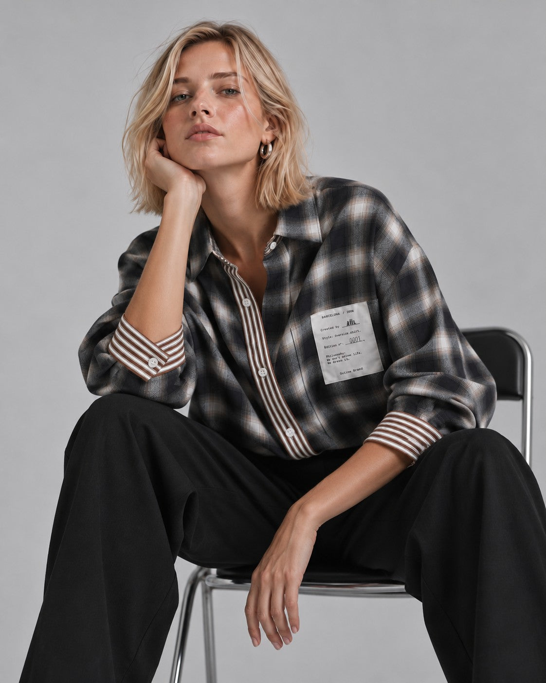 Mujer con camisa oversize de cuadro AÜL, modelo Authentic Undefined Life, bolsillo con etiqueta numerada
