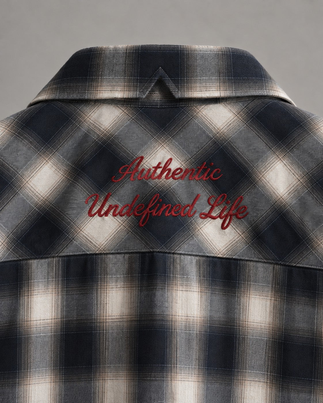 Detalle bordado 'Authentic Undefined Life' en rojo, espalda de camisa oversize AÜL