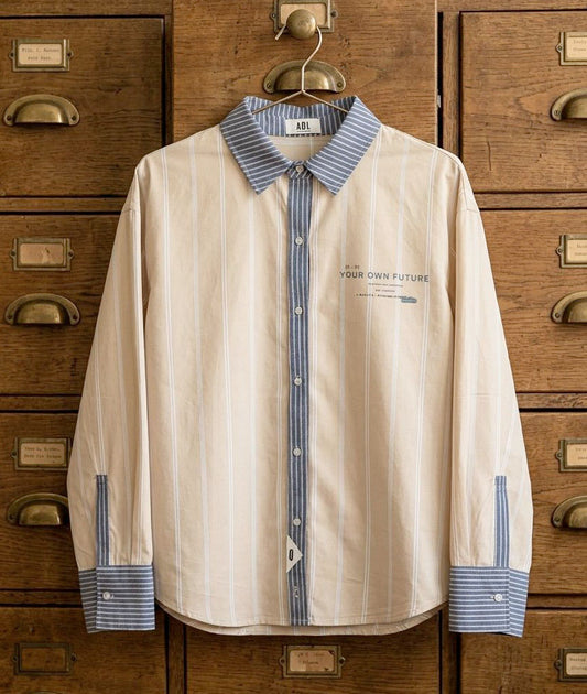 Camisa aul  unisex de estilo oversize  y con tejidos de algodón premium, camisa combinada con dos tejidos de rayas en tonos diferentes y contrastados. Frase estampada en el delantero y etiqueta con número de serie. Fit relajado de estilo minimalista moderno y urbano.
