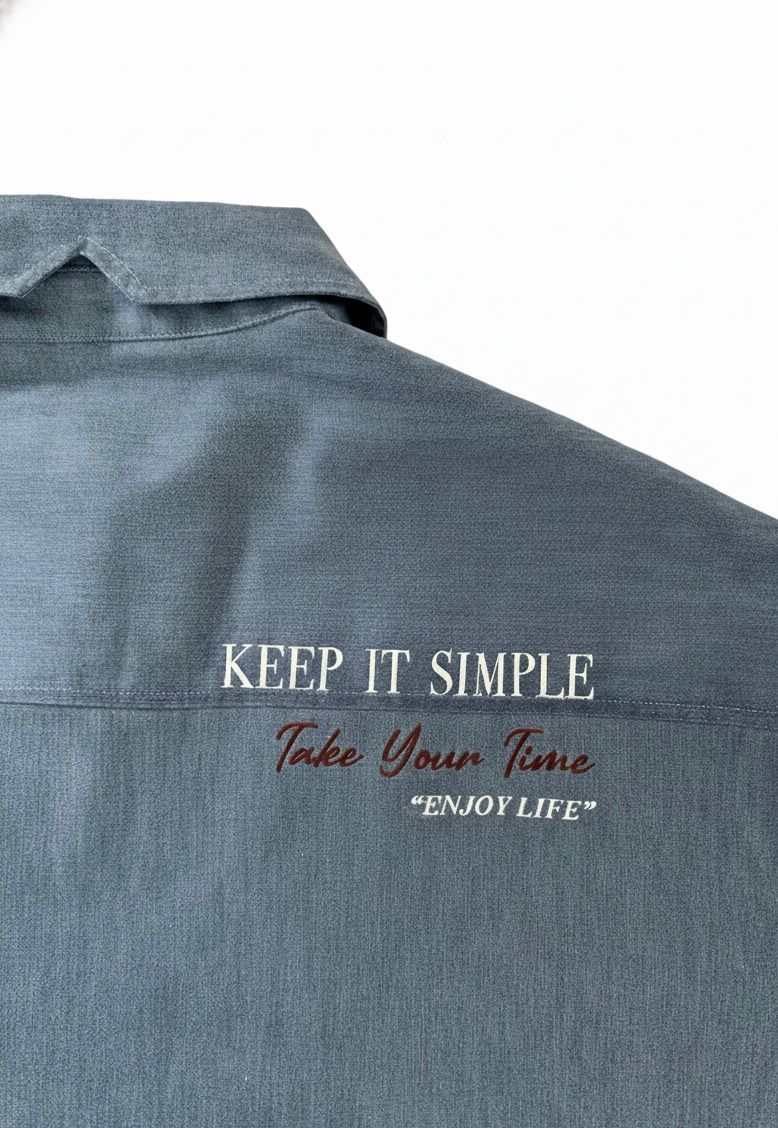 Camisa unisex de estilo  oversize con tejido algodón efecto denim y contraste en interior cuello y puños con un tejido de rayas, fit relajado estilo minimalista y moderno y urbano. estampado en la espalda y en el bolsillo delantero una etiqueta con número de serie exclusivo y personalizado