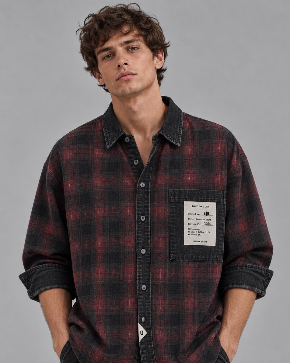 Modelo con camisa oversize de cuadros y denim negro, look unisex y etiqueta con edición numerada